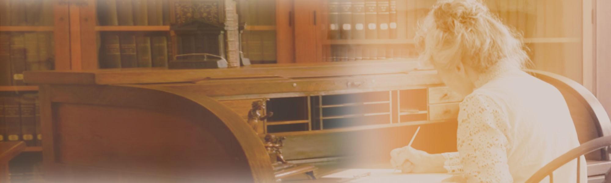 Myrle Fillmore sitting at desk writing