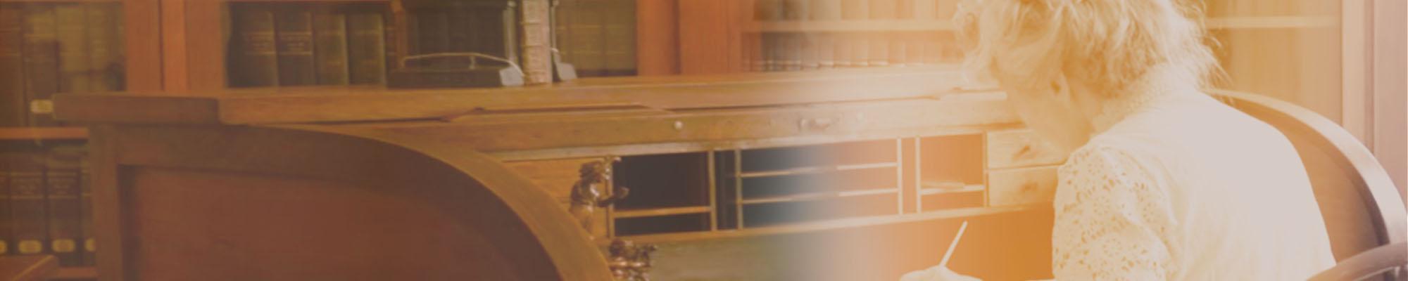 Myrle Fillmore sitting at desk writing