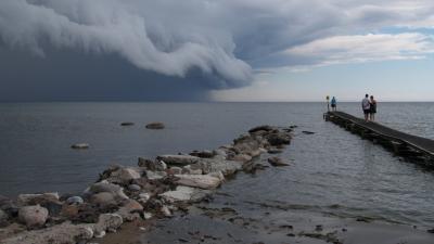 People on dock stormy clouds