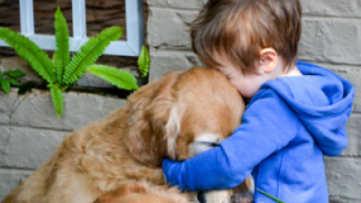 Little boy hugging dog