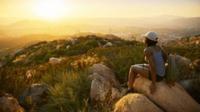 Woman sitting on rocks sun
