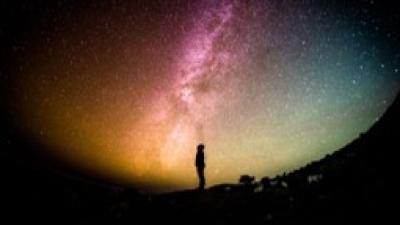 Person standing looking up to the universe