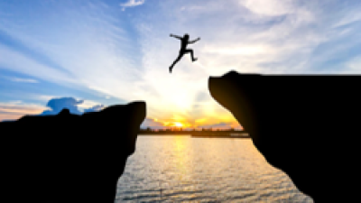 Boy jumping from rock to rock